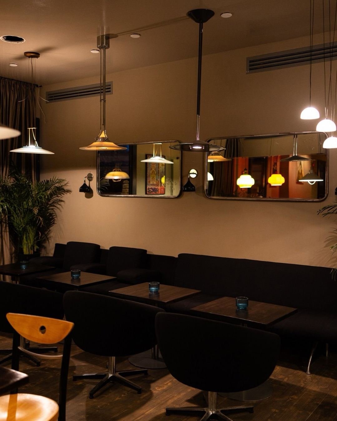 The dining room of Tevzebi at night — warm pendant lamps, dark banquettes